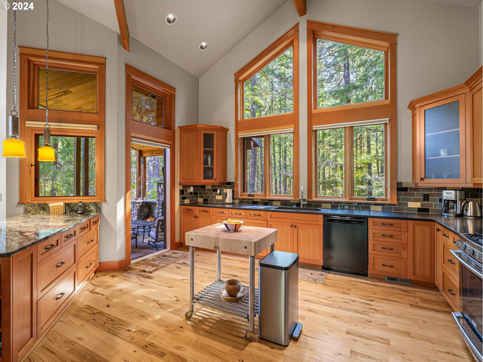 20803 East Glacier View Road Rhododendron, OR 97049 - Photo 12 of 48 a large kitchen with granite countertop a stove a sink and a dining table
