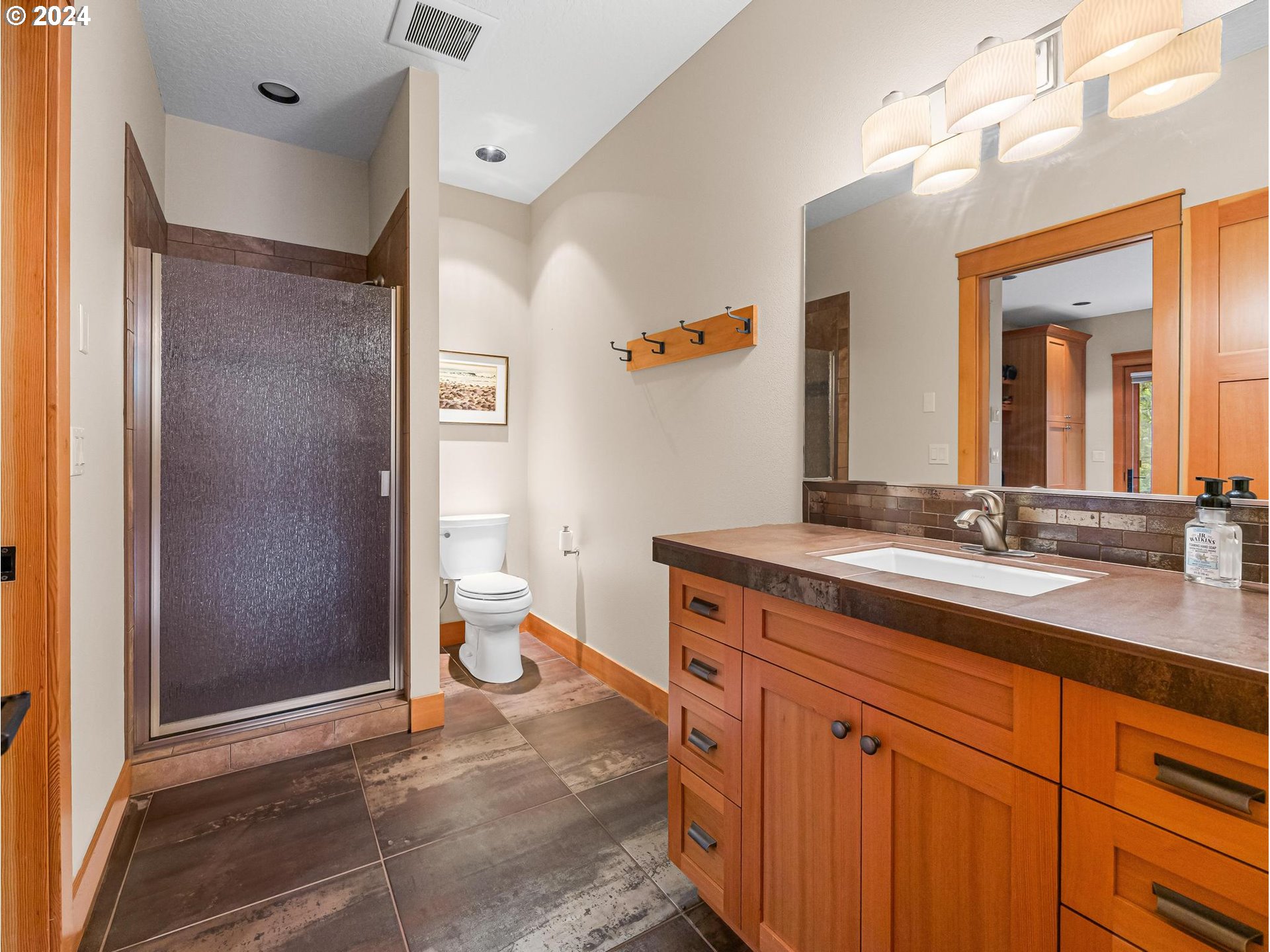 20803 East Glacier View Road Rhododendron, OR 97049 - Photo 19 of 48 a spacious bathroom with a granite countertop sink a toilet a mirror and shower