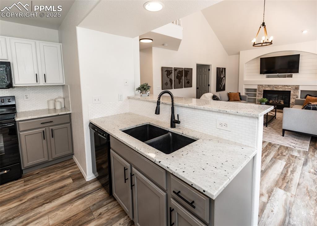 508 Fox Run Circle Colorado Springs, CO 80921 - Photo 16 of 50 a kitchen with granite countertop a sink and a stove top oven with wooden floor