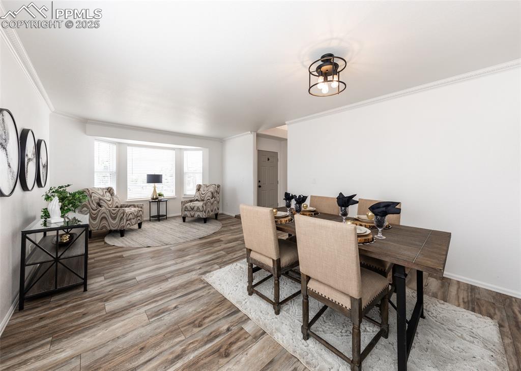 508 Fox Run Circle Colorado Springs, CO 80921 - Photo 9 of 50 a view of a dining room and livingroom with furniture wooden floor a rug and a chandelier