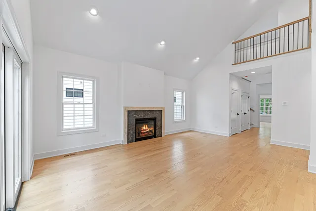 a view of an empty room with a window and fireplace
