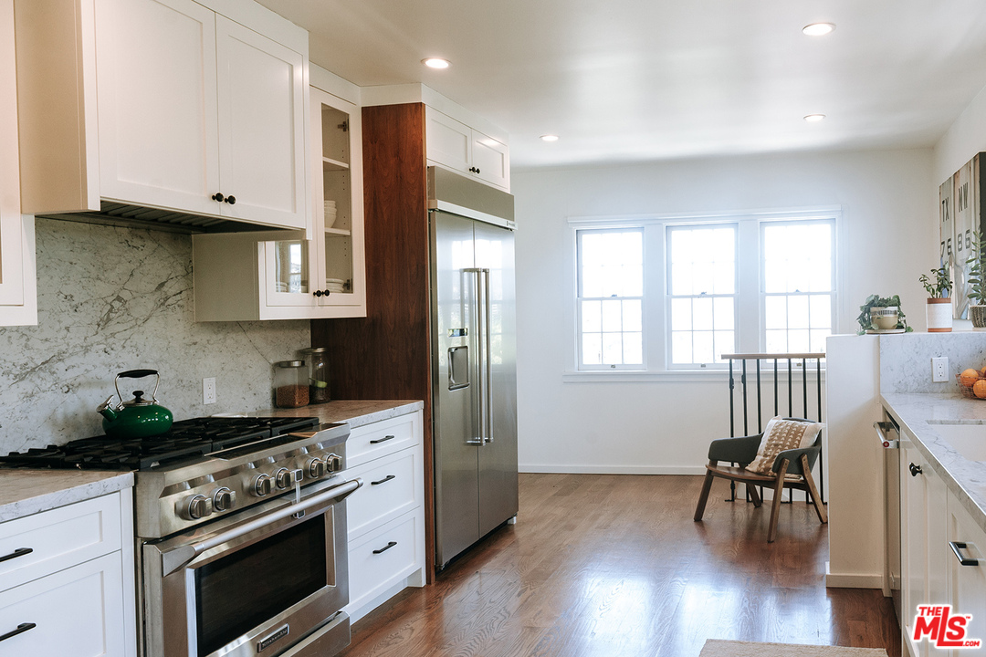 1341 Edgecliffe Drive Los Angeles, CA 90026 - Photo 19 of 51 a kitchen with stainless steel appliances white cabinets and a stove top oven