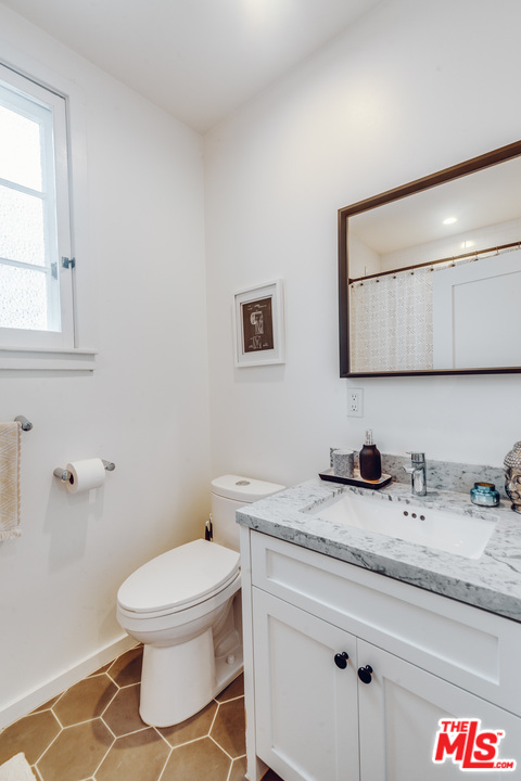 1341 Edgecliffe Drive Los Angeles, CA 90026 - Photo 29 of 51 a bathroom with a granite countertop toilet sink and mirror