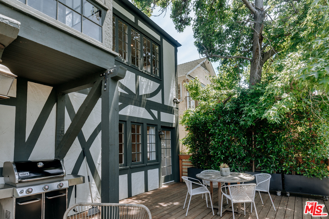 1341 Edgecliffe Drive Los Angeles, CA 90026 - Photo 37 of 51 a view of a patio with table and chairs and potted plants with wooden floor and fence