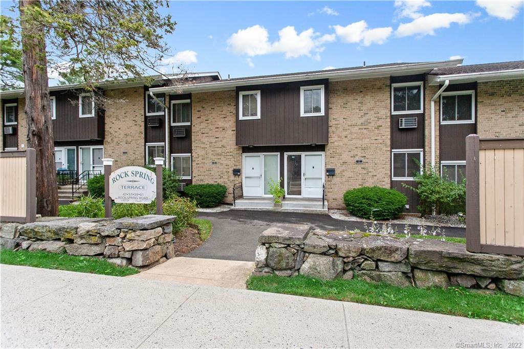 a front view of a house with a garden and plants
