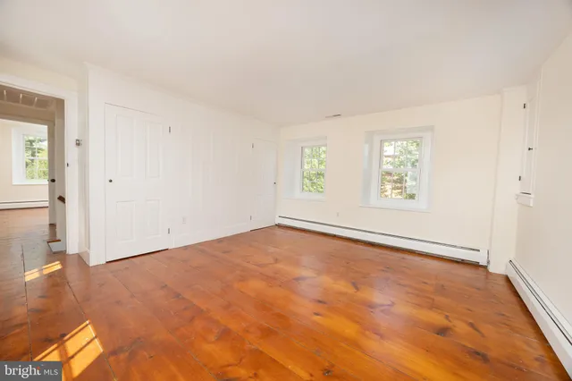 an empty room with windows and closet