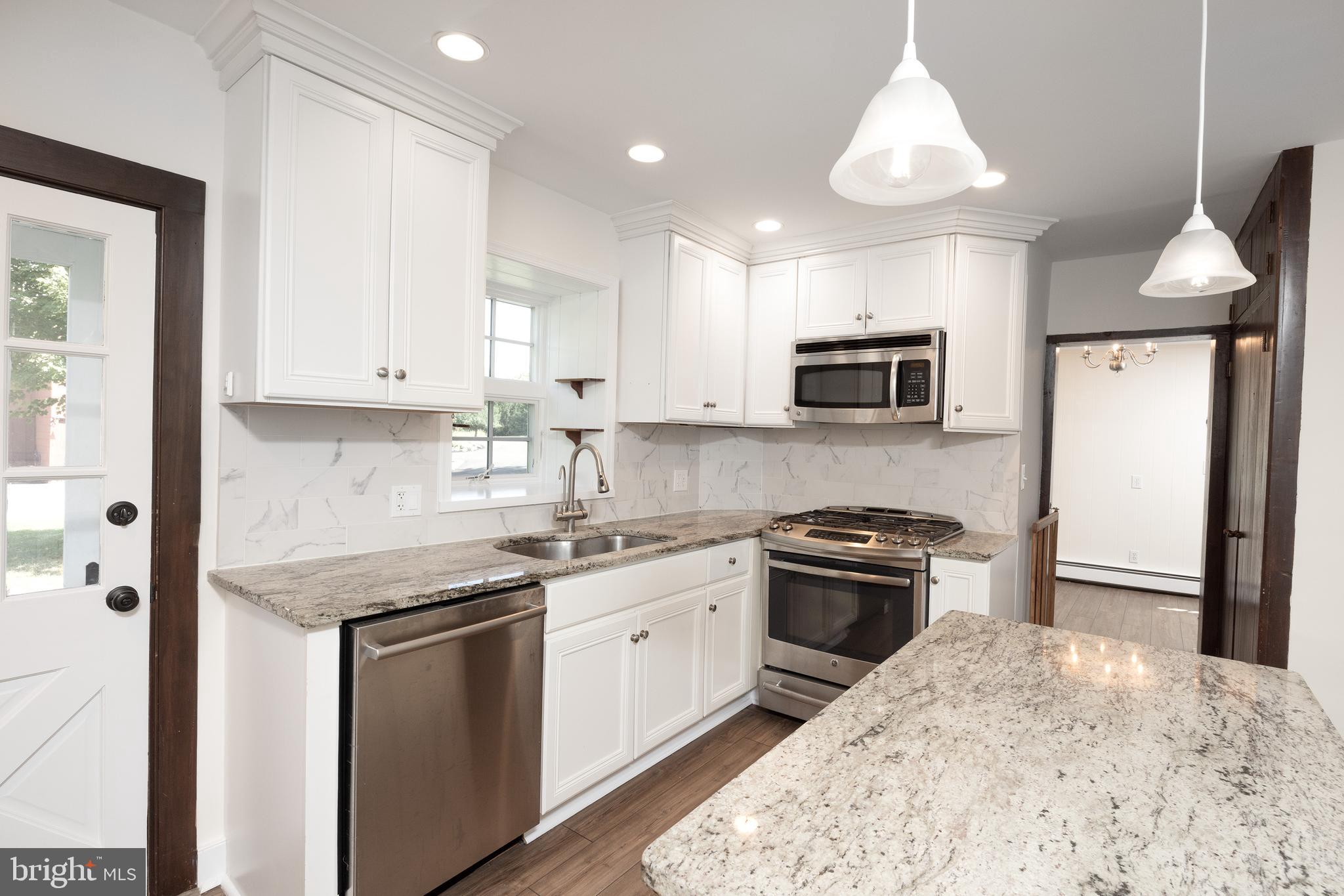 4001 Street Road Doylestown, PA 18902 - Photo 9 of 38 a kitchen with stainless steel appliances granite countertop a stove top oven a sink a microwave and a refrigerator