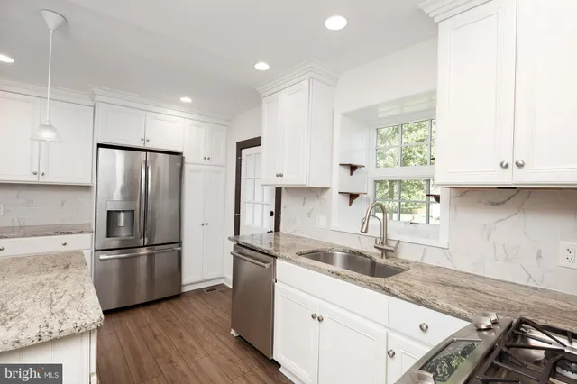 a kitchen with stainless steel appliances granite countertop a refrigerator sink and cabinets