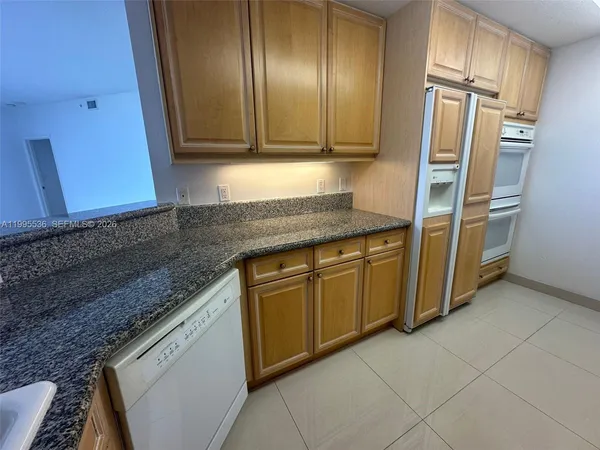a view of a hallway with a livingroom and a bathroom with sink