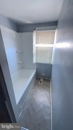 a bathroom with a tub and a window