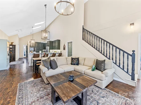 a living room with furniture a rug and kitchen view