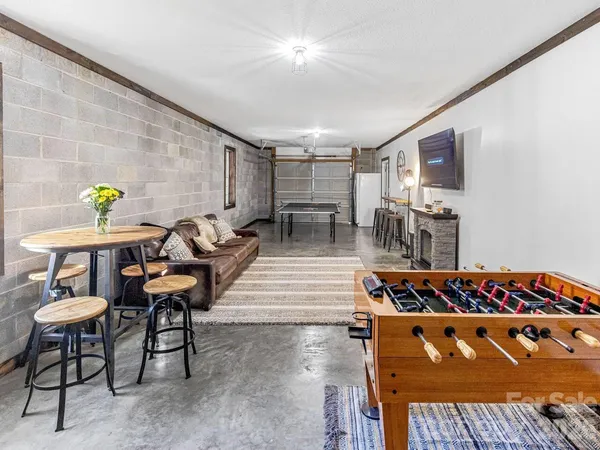 a living room with furniture a table and kitchen view