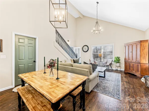 a living room with furniture kitchen view and a wooden floor