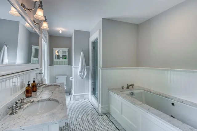 a bathroom with a tub sink and mirror