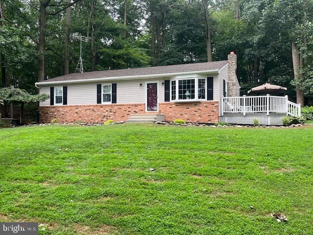 a front view of a house with a yard and trees