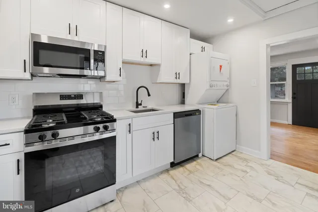 a kitchen with cabinets stainless steel appliances and wooden floor