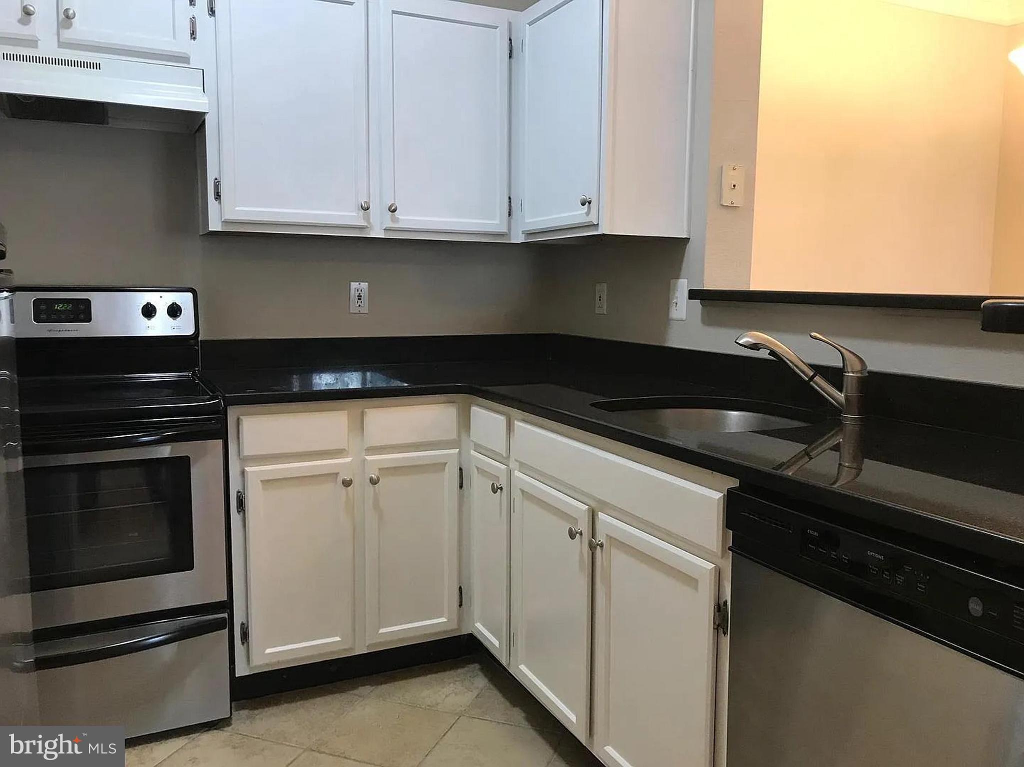 1580 Spring Gate Dr., Unit 4314 McLean, VA 22102 - Photo 12 of 36 a kitchen with granite countertop white cabinets and a stove