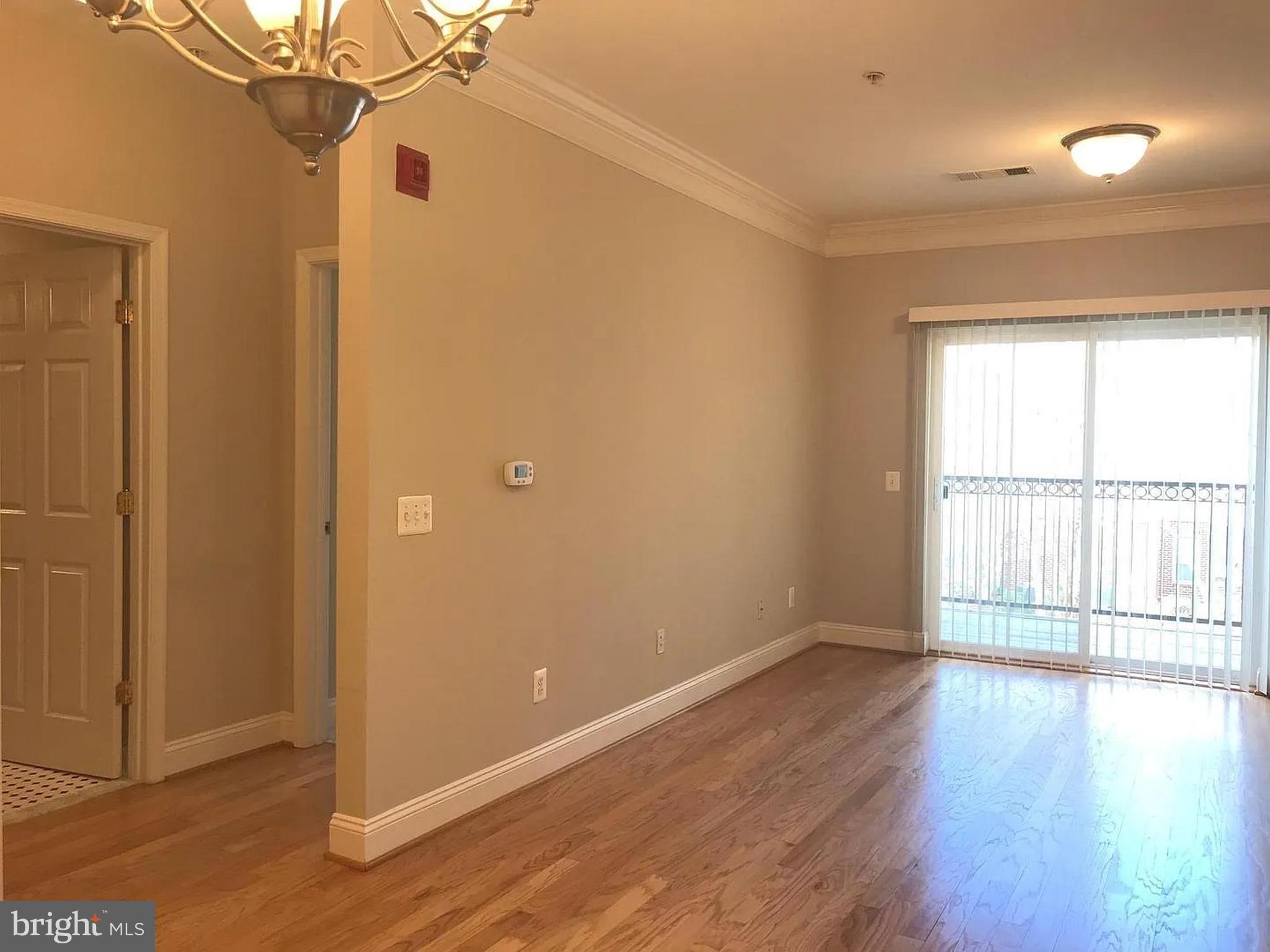 1580 Spring Gate Dr., Unit 4314 McLean, VA 22102 - Photo 7 of 36 an empty room with wooden floor and windows