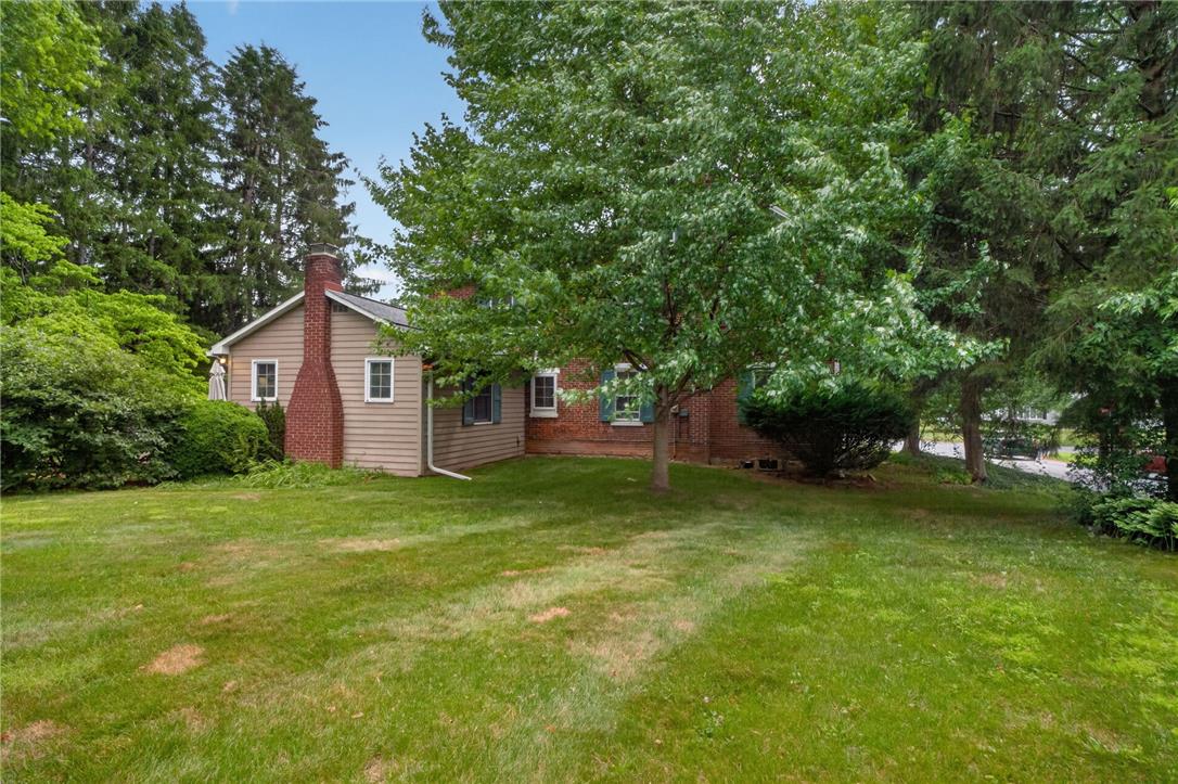 765 East Macada Road Bethlehem, PA 18017 - Photo 44 of 46 A classic brick chimney and beige siding adorn this home, nestled among mature trees and a verdant lawn.