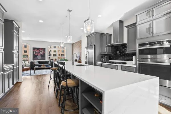 a large kitchen with stainless steel appliances and a wooden floor