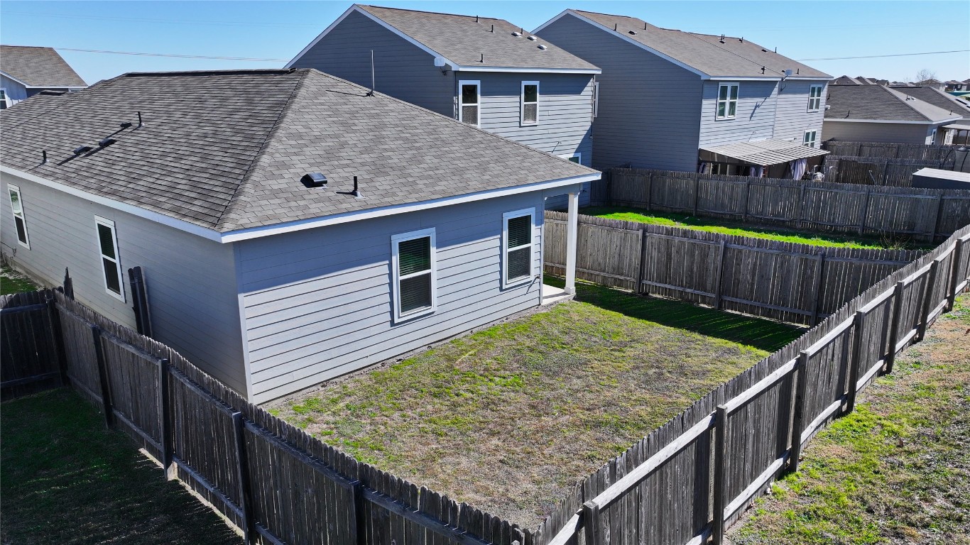 125 Woodpecker Run Jarrell, TX 76537 - Photo 19 of 22 View of side of property with roof with shingles, a fenced backyard, and a residential view