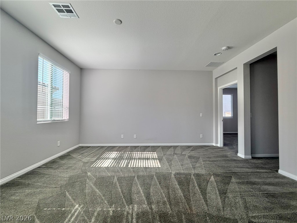 9953 Tucket Point Court Las Vegas, NV 89178 - Photo 12 of 22 An airy great room featuring plush carpet flooring and a sun-filled window with blinds.