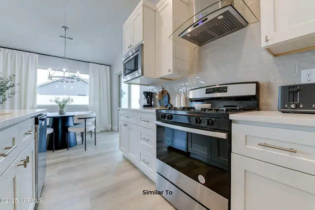 a kitchen with stainless steel appliances a stove a sink and a refrigerator