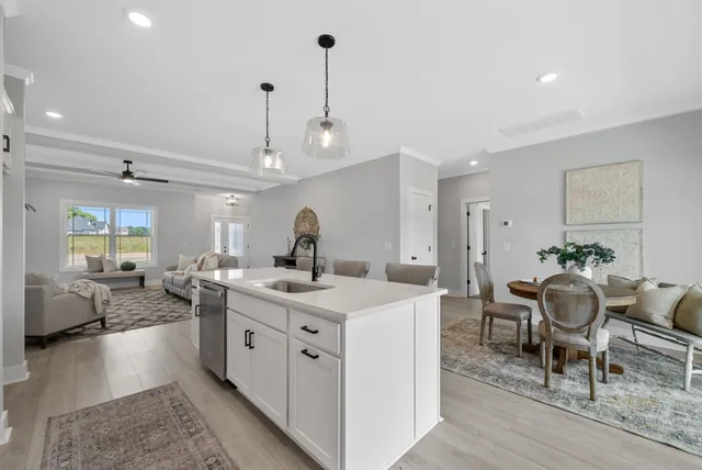 a large white kitchen with sink and stove