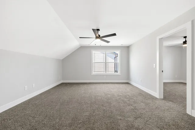 an empty room with windows and ceiling fan