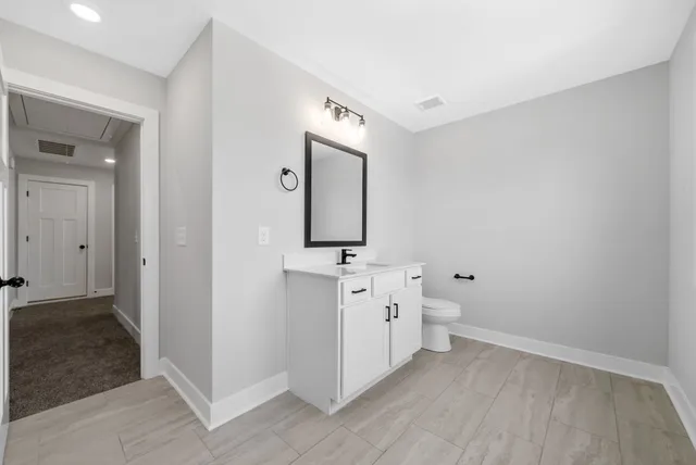 wooden floor in a en suite bathroom with a sink and a mirror