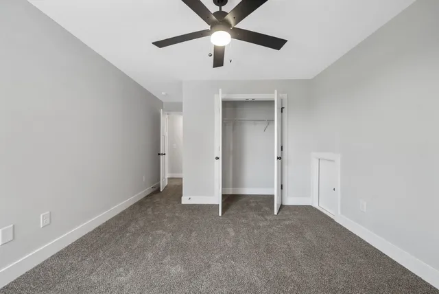 an empty room with a ceiling fan and a window