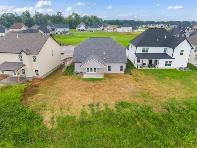 an aerial view of residential houses with outdoor space and a lake view