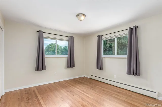 an empty room with stairs and wooden floor