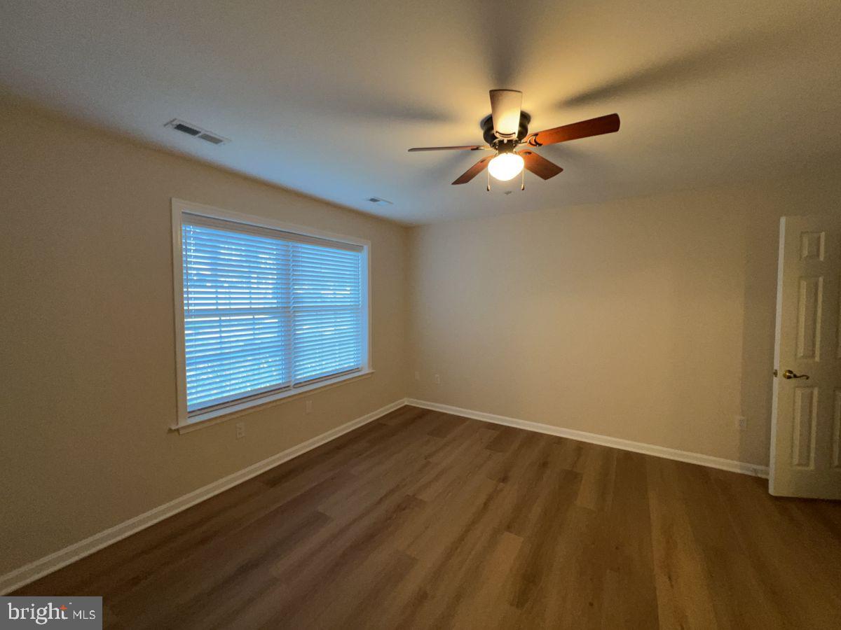 2400 Ellsworth Way, Unit 1C Frederick, MD 21702 - Photo 11 of 17 a view of an empty room with wooden floor and a window