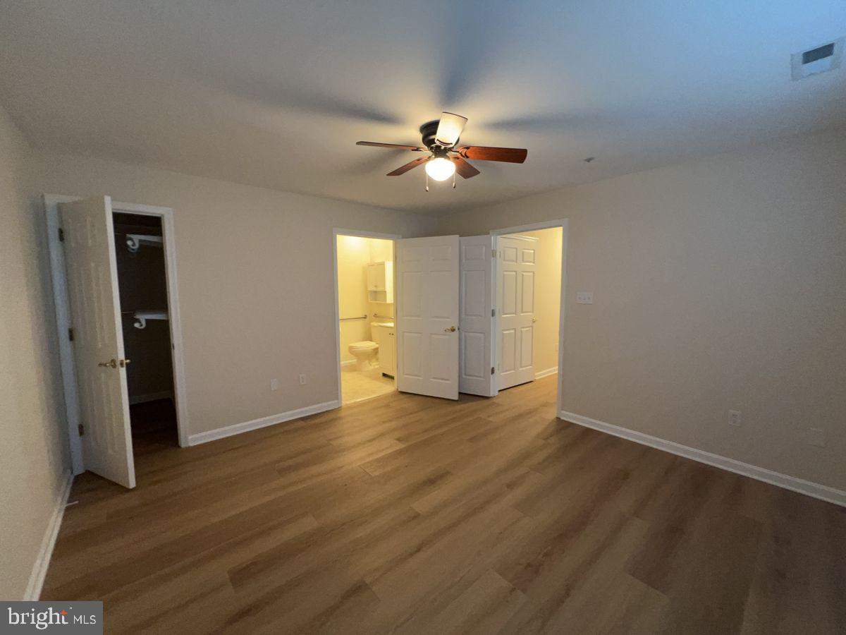 2400 Ellsworth Way, Unit 1C Frederick, MD 21702 - Photo 12 of 17 an empty room with wooden floor ceiling fan and window