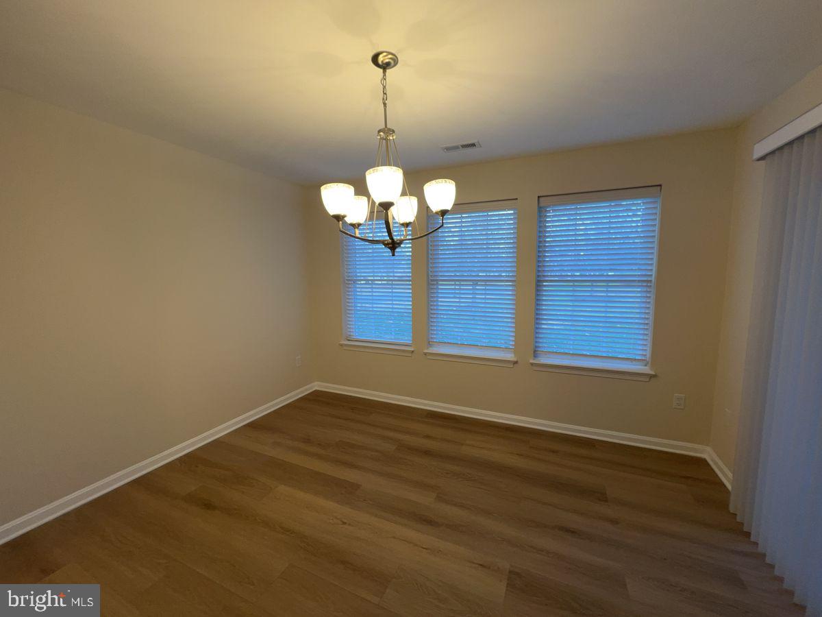 2400 Ellsworth Way, Unit 1C Frederick, MD 21702 - Photo 4 of 17 a view of a room with wooden floor and chandelier