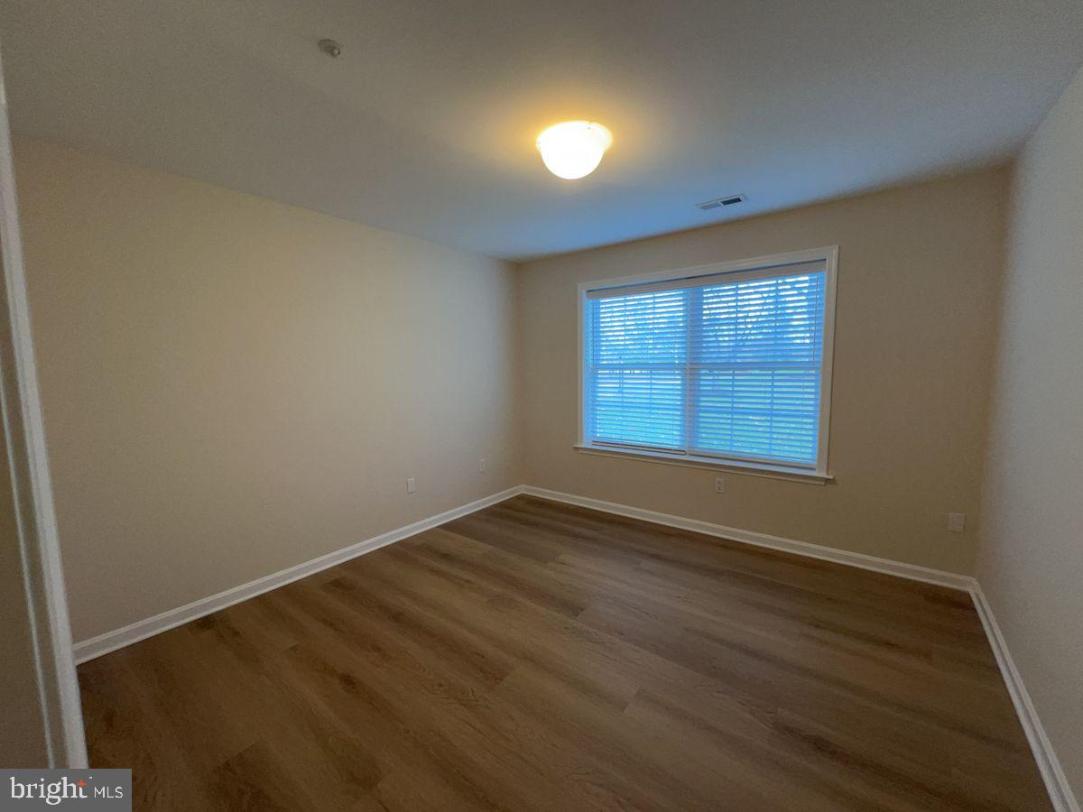 2400 Ellsworth Way, Unit 1C Frederick, MD 21702 - Photo 9 of 17 an empty room with wooden floor and windows