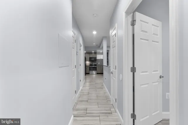 a view of a hallway with wooden floor and staircase