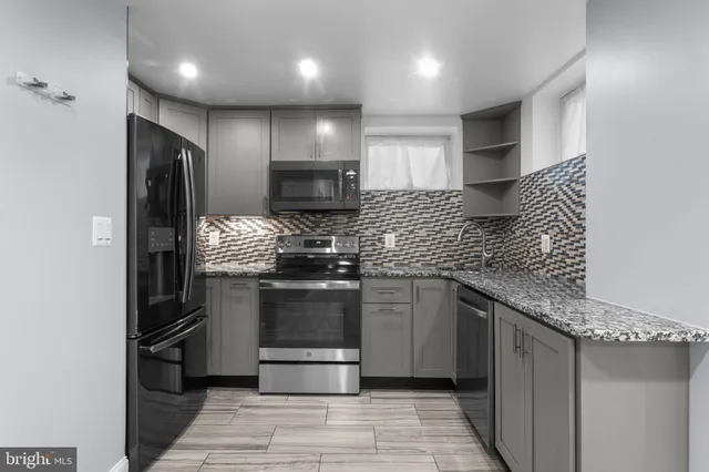 a kitchen with kitchen island stainless steel appliances a sink stove and refrigerator
