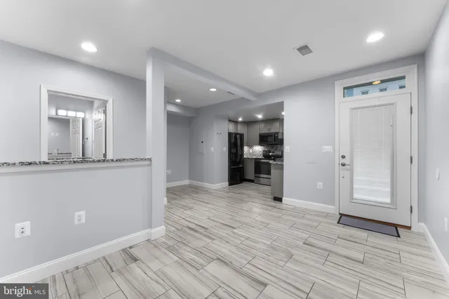 a view of a hallway with wooden floor and kitchen