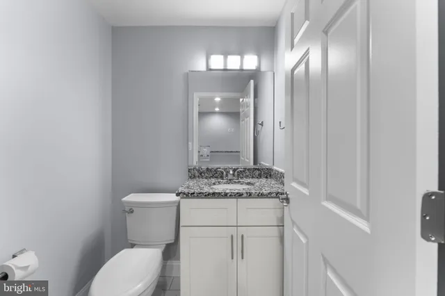 a bathroom with a toilet a sink and mirror