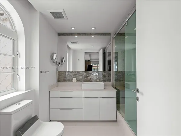 a view of a hallway with wooden floor and a bathroom