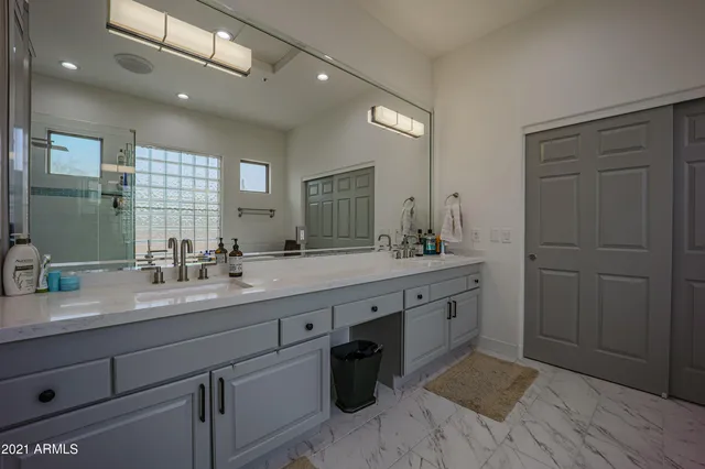 a spacious bathroom with a granite countertop sink a toilet and a mirror