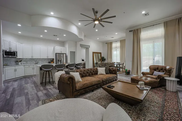a living room with furniture kitchen and a large window