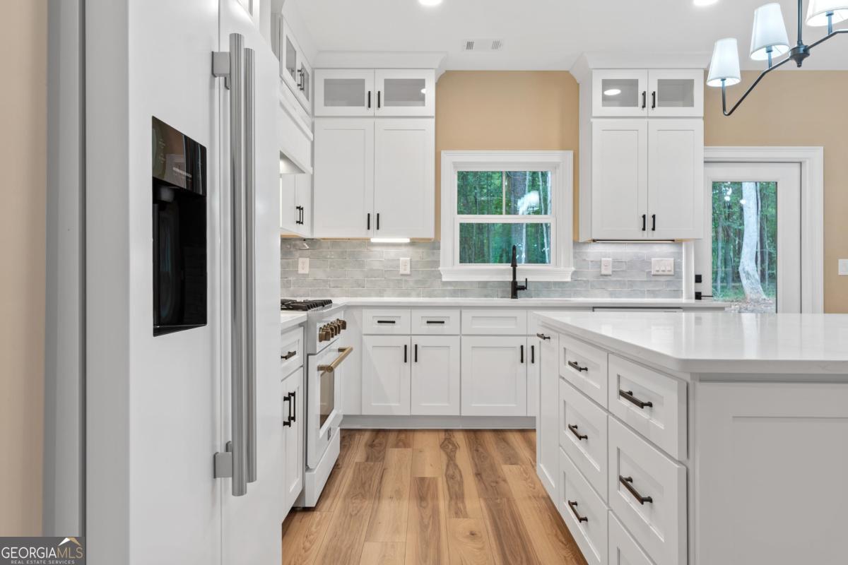 118 Southshore Road Eatonton, GA 31024 - Photo 13 of 42 a kitchen with granite countertop a sink stove and cabinets
