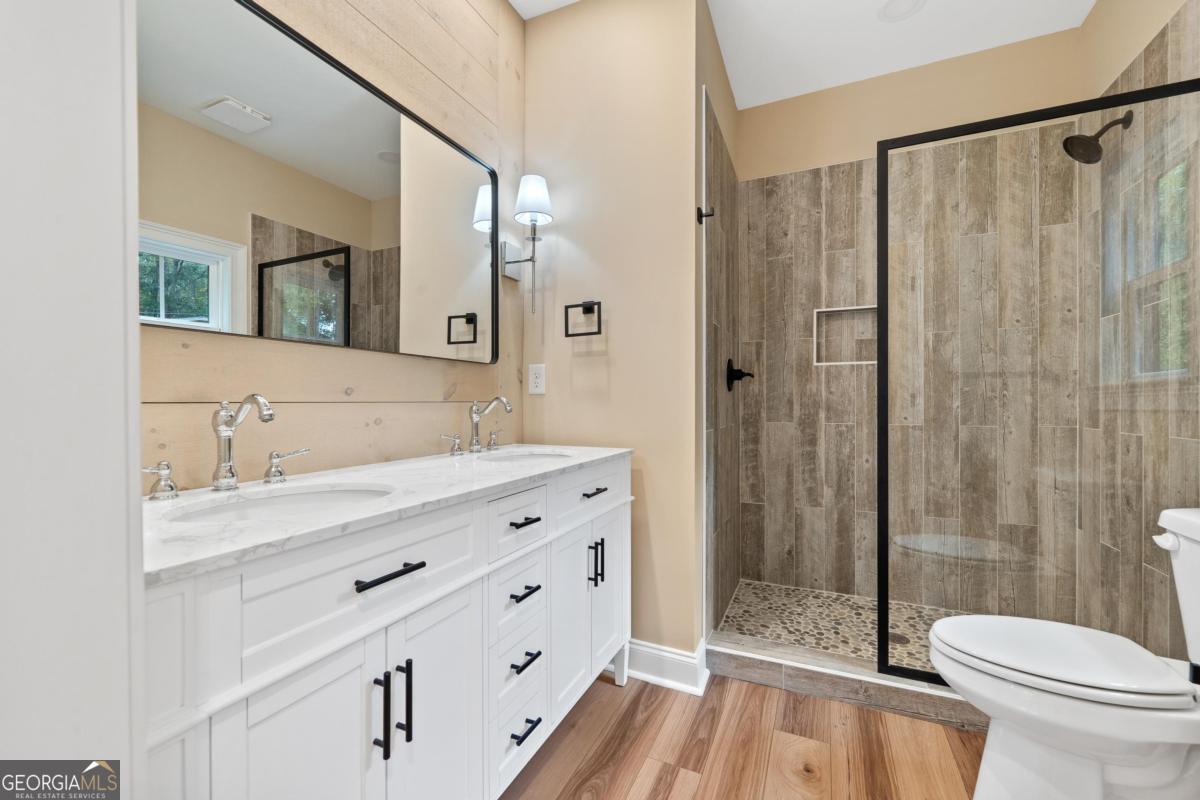 118 Southshore Road Eatonton, GA 31024 - Photo 26 of 42 a bathroom with a double vanity sink toilet and shower