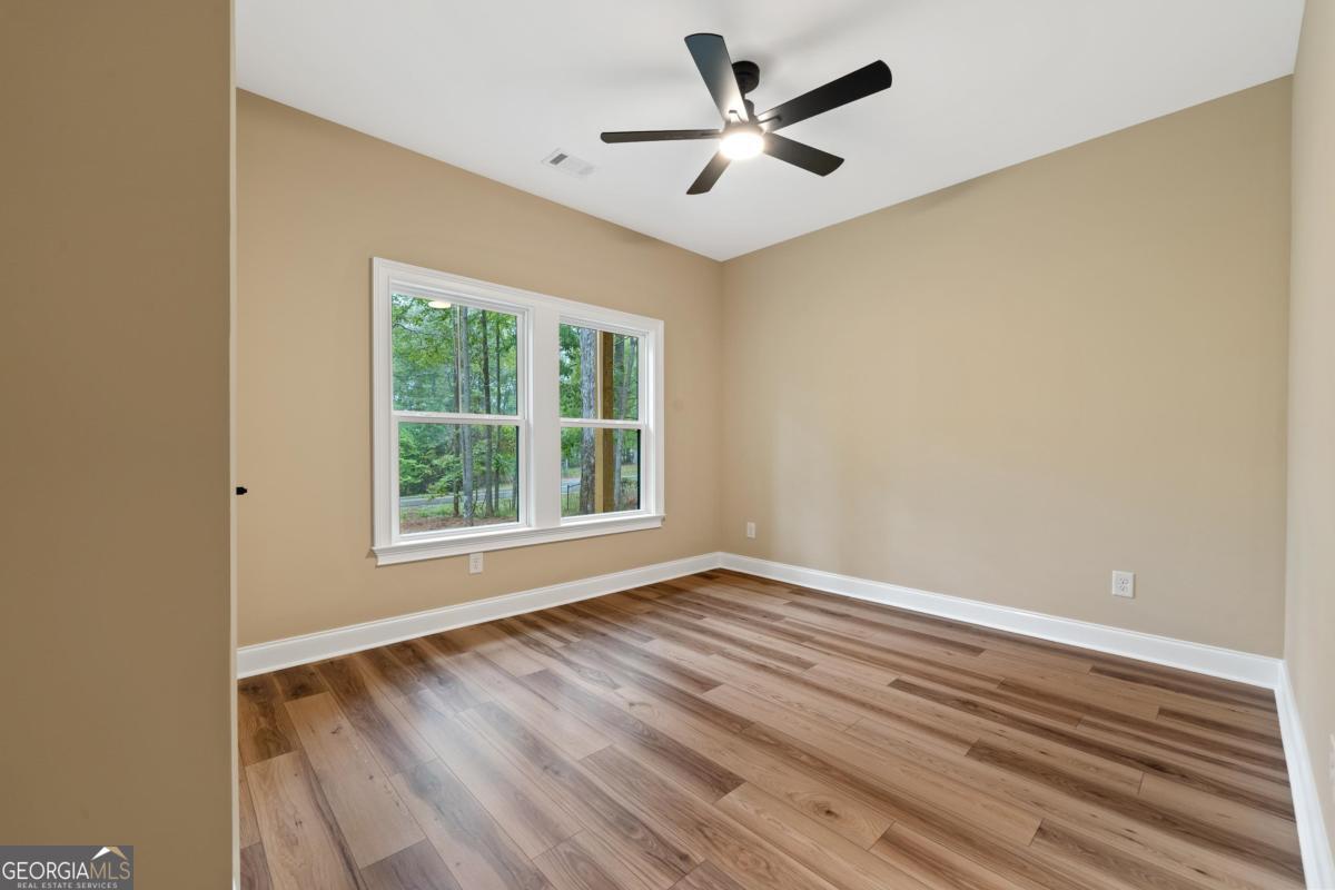 118 Southshore Road Eatonton, GA 31024 - Photo 34 of 42 an empty room with wooden floor and windows