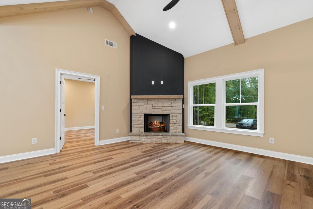 118 Southshore Road Eatonton, GA 31024 - Photo 8 of 42 a view of an empty room with wooden floor fireplace and a window