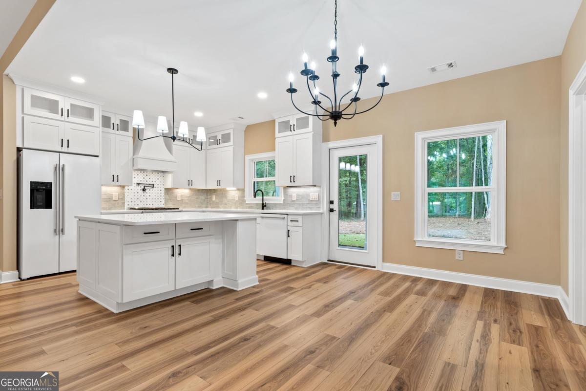 118 Southshore Road Eatonton, GA 31024 - Photo 9 of 42 a kitchen with stainless steel appliances granite countertop a refrigerator a stove a oven and white cabinets with wooden floor