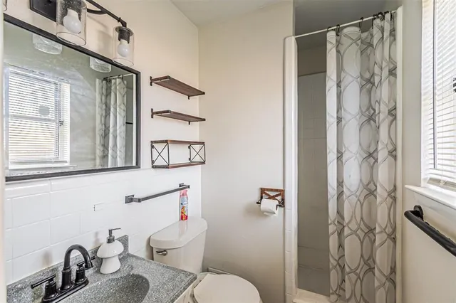 a bathroom with a sink toilet and shower